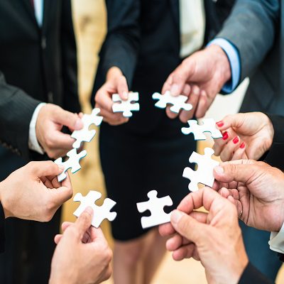 Teamwork – Business people solving a puzzle